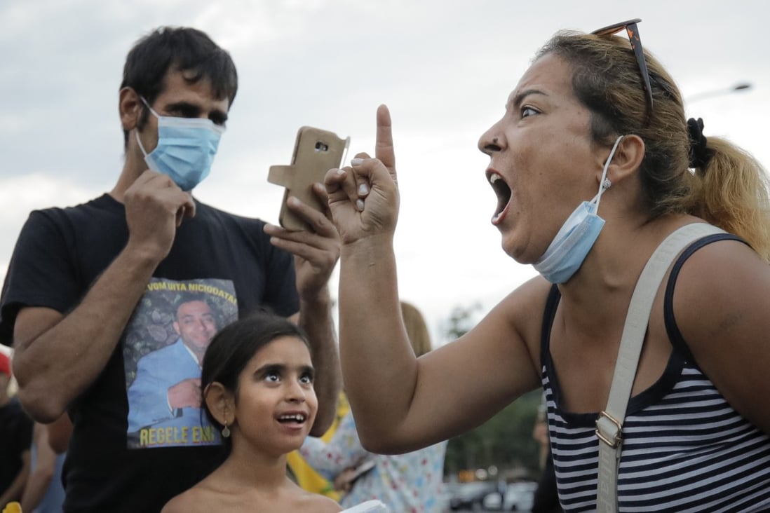 A woman shouts against the government's measures to prevent the spread of Covid-19 infections, like wearing a face mask, during a rally in Bucharest, Romania. Photo: AP