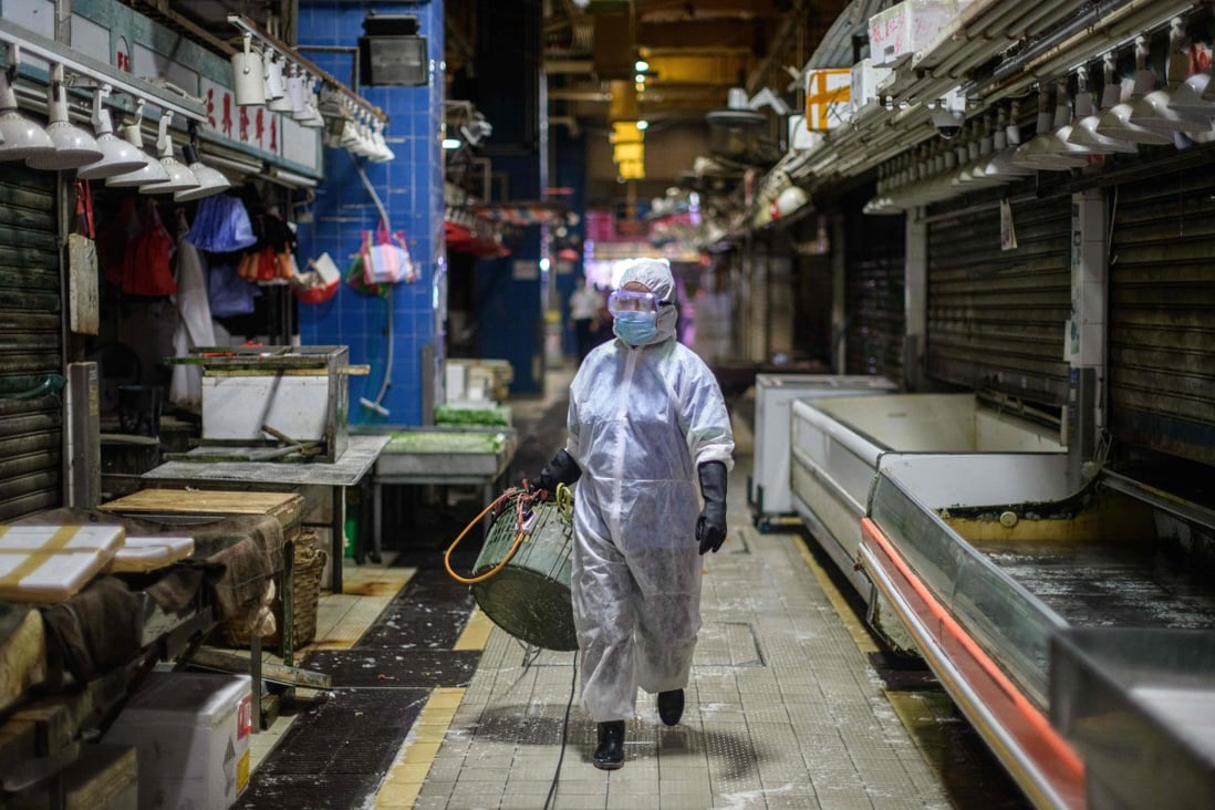 A Food and Environmental Hygiene Department contractor cleans and disinfects Pei Ho Street Market in the Sham Shui Po district of Hong Kong on July 17, amid a third wave of Covid-19. Photo: AFP