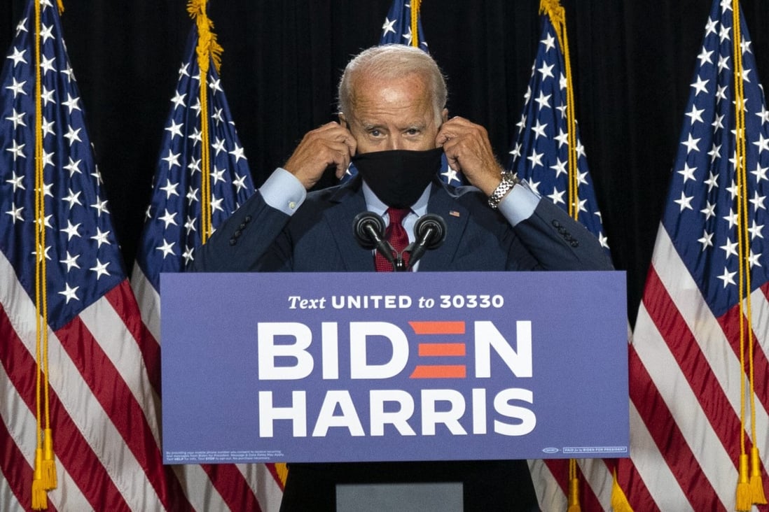 Democratic presidential candidate Joe Biden removes his face mask as he prepares to speak at the Hotel DuPont in Wilmington, Delaware, on Thursday. Photo: AP