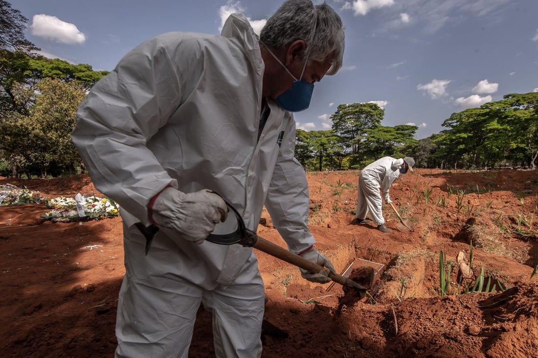 Gravediggers wearing protective gear bury caskets of Covid-19 victims at the Vila Formosa cemetery in Sao Paulo, Brazil. Photo: Bloomberg