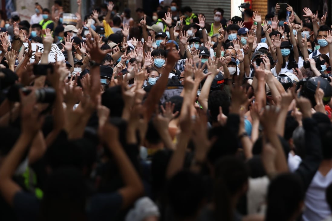 Anti-government protesters holds up their hands to symbolise their five demands during a demonstration on July 1 in Causeway Bay. Hong Kong has been roiled by one crisis after another since mid-2019 – from the anti-government protests to the coronavirus pandemic. Photo: Xiaomei Chen