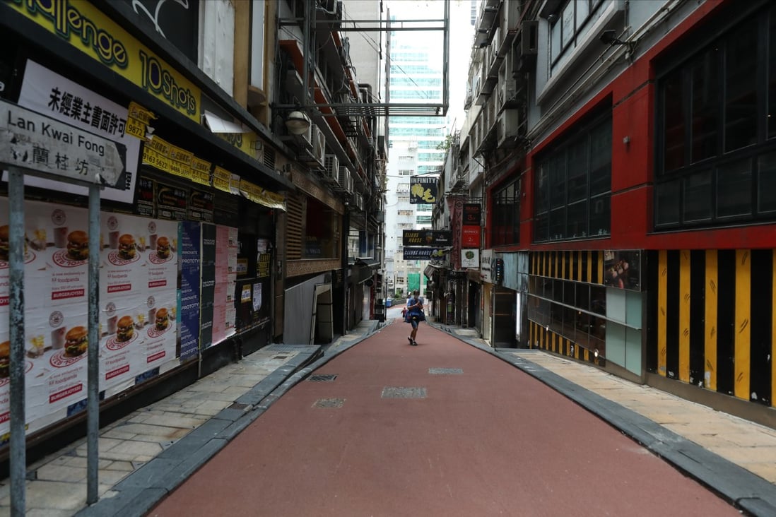 A lone person walks down a street lined by closed bars in Lan Kwai Fong, Central, amid the third wave of coronavirus infections on July 29. Photo: Nora Tam