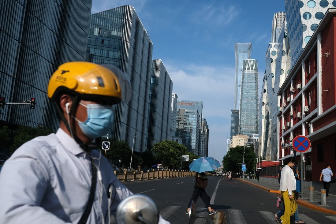 A Meituan Dianping delivery worker crosses a street in Beijing's central business area on June 30. Photo: Reuters