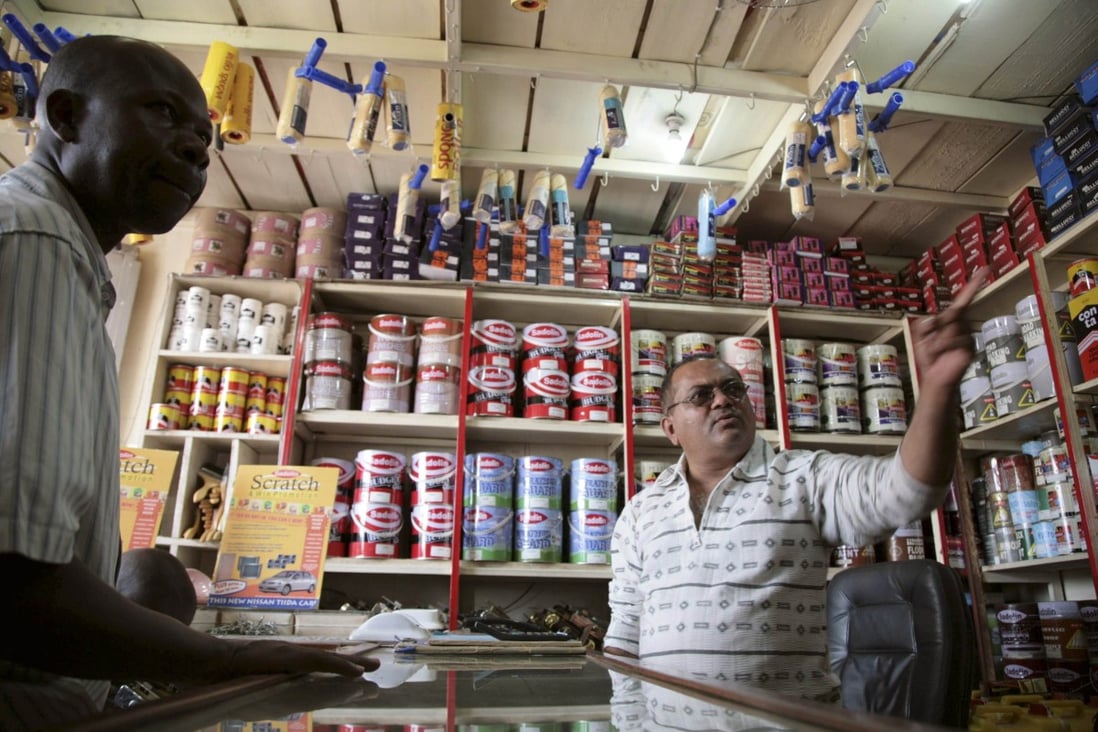 Jay Shree, a businessman of Asian origin, serves a customer in his store in Kampala, Uganda. Photo: Reuters