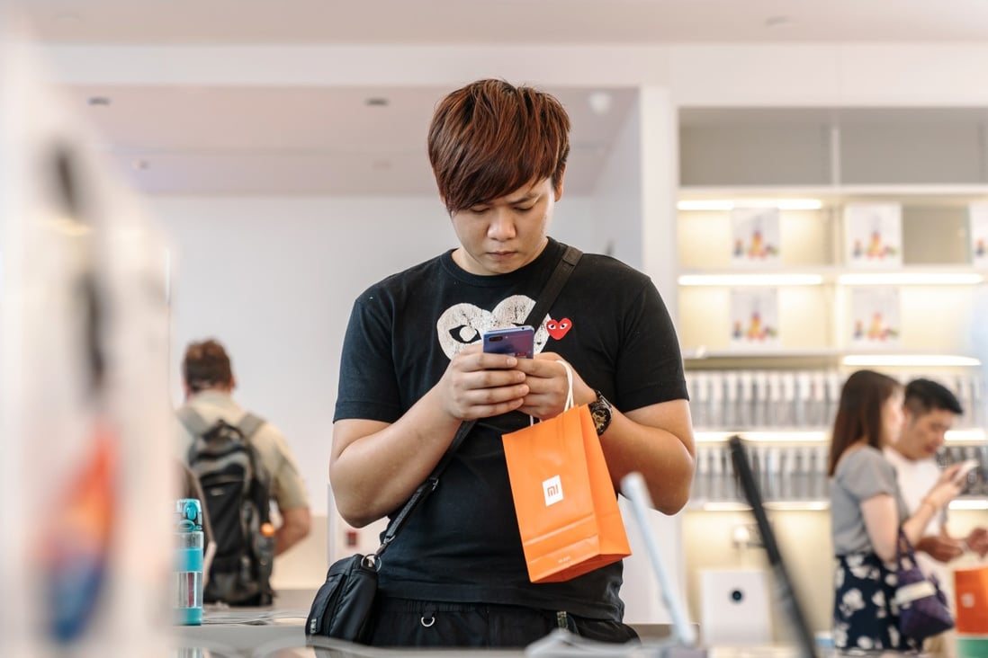 A customer looks at a Xiaomi phone at the company’s store in Hong Kong. Photo: Bloomberg
