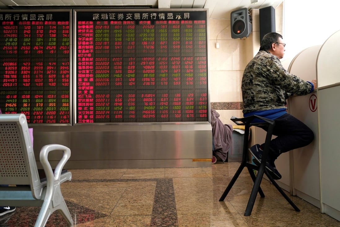 An investor sits next to a stock quotation board at a brokerage office in Beijing. Photo: Reuters
