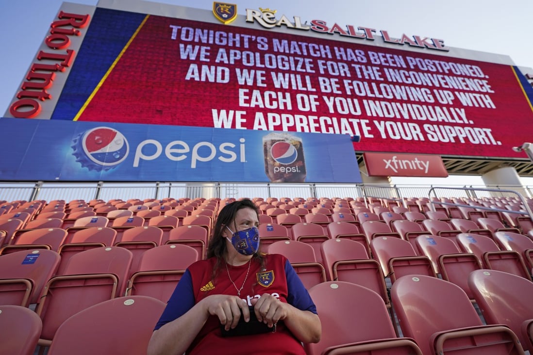 A fan sits in the stands under an announcement that the MLS game between Real Salt Lake and Los Angeles FC had been postponed in Sandy, Utah. Photo: AP