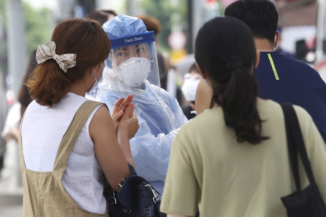 A medical worker and test subjects at a makeshift clinic in Seoul, South Korea. Photo: AP