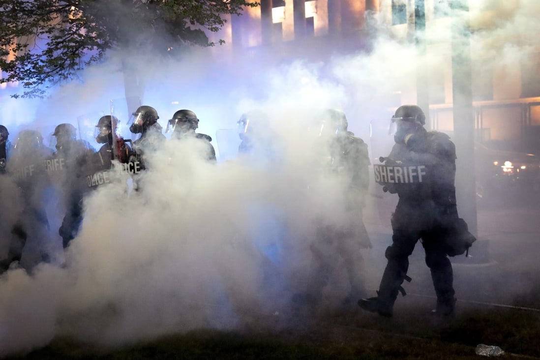 Police try to push back protesters as tear gas fills the air in Kenosha, Wisconsin, as unrest continues following the shooting of Jacob Blake. Photo: AFP