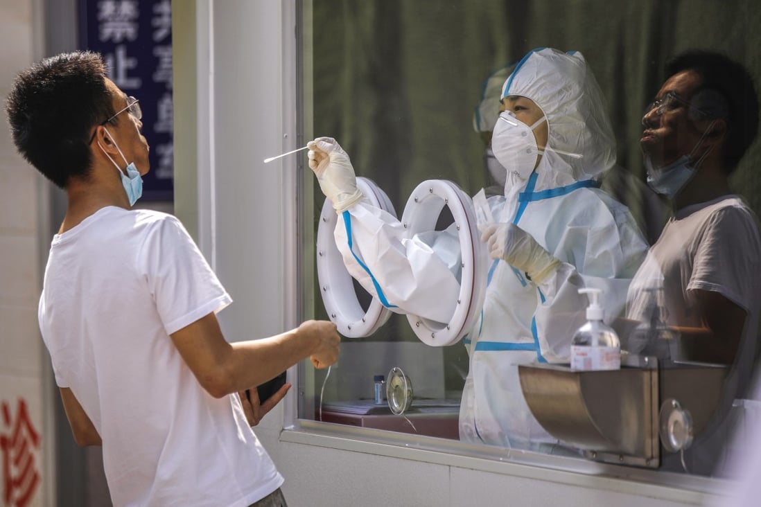 A medical worker wearing a full protective outfit tests a man for the novel coronavirus at a hospital in Beijing, China, 14 July 2020. Photo: EPA-EFE