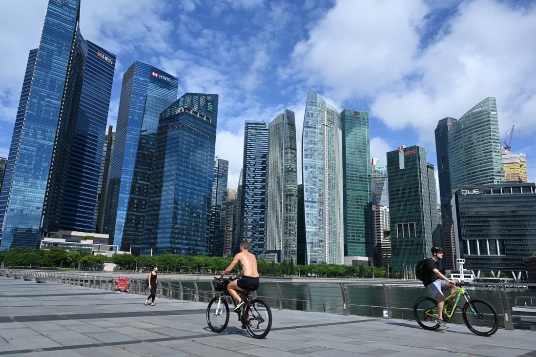 Cyclists pedal down the Marina Bay promenade, flanked by skyscrapers housing banks and other financial institutions, in Singapore. Photo: AFP