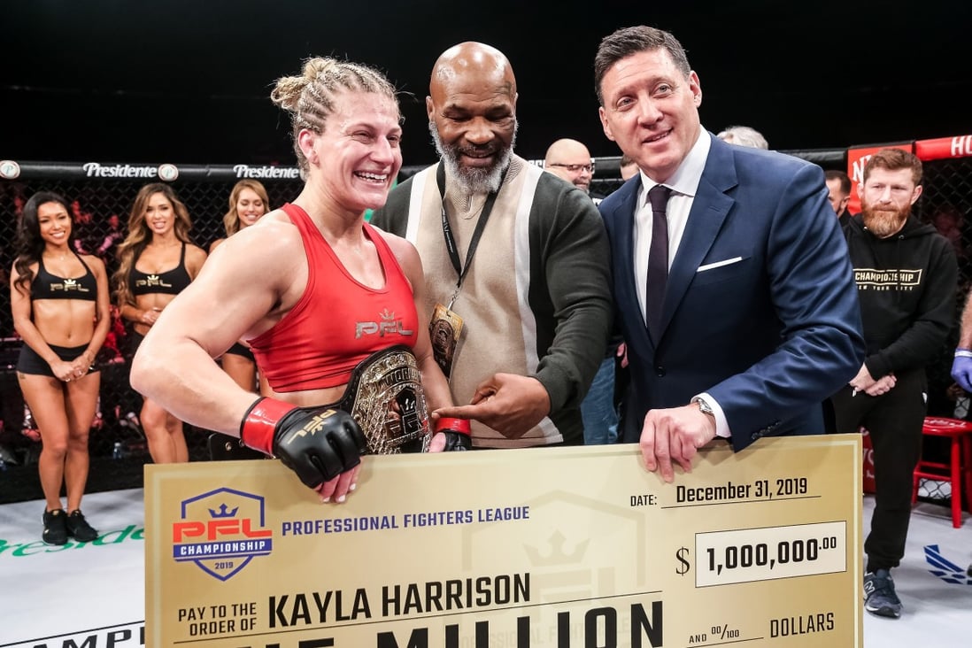 Mike Tyson hands out a PFL 2019 championship belt and a cheque for US$1 million to Kayla Harrison (left), alongside PFL CEO Peter Murray. Photos: PFL