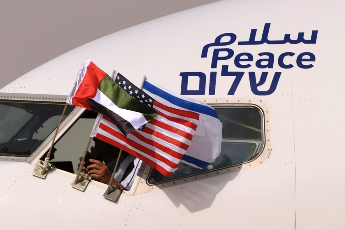 The Emirati, Israeli and US flags are picture attached to an El Al plane adorned with the word “peace” in Arabic, English and Hebrew, upon its arrival at the Abu Dhabi airport after the first-ever commercial flight from Israel to the UAE. Photo: AFP