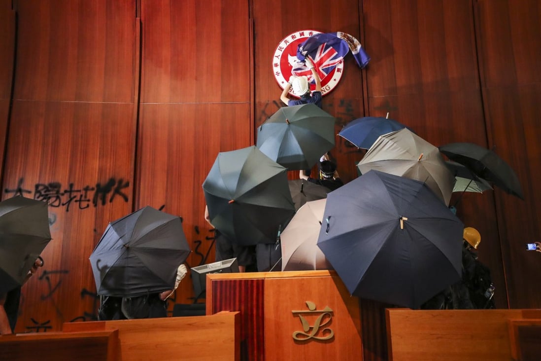 Protesters storm Hong Kong’s Legco chamber last year. Police are now hunting for suspects involved in the case. Photo: Sam Tsang