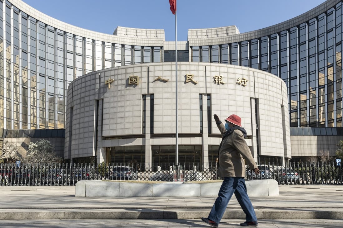 A pedestrian wearing a protective mask walks past the People’s Bank of China building in Beijing on March 17. China suffered an even deeper slump than analysts feared at the start of the year as the coronavirus shuttered factories, shops and restaurants across the nation, underscoring the fallout now facing the global economy. Photo: Bloomberg