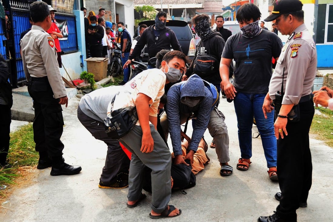 Indonesia’s specialist counterterrorism police unit apprehends a suspected militant outside a home in Bekasi, West Java. A new report looks into the reasons why released terror convicts take part in terror activities again. Photo: AFP