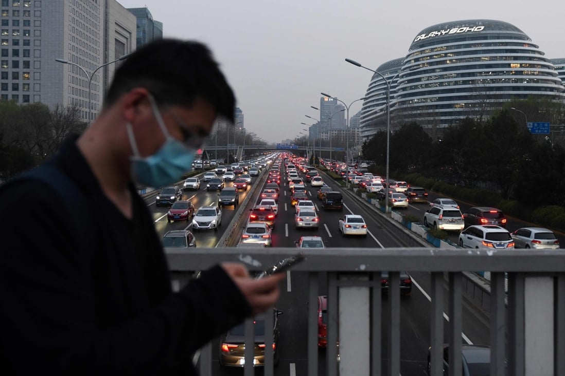 A man walks past Beijing’s Second Ring Road crowded with cars on March 24. Photo: AFP