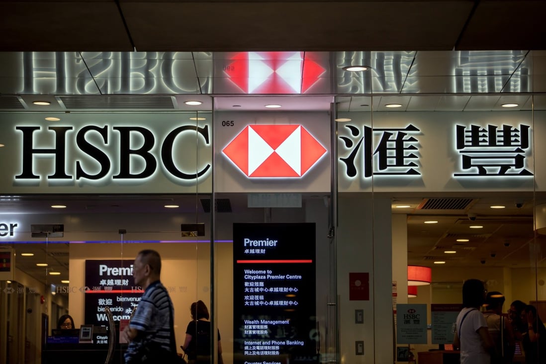 A pedestrian walks past an HSBC branch in Hong Kong. The bank will eliminate more fees from November to fend of competition. Photo: Bloomberg