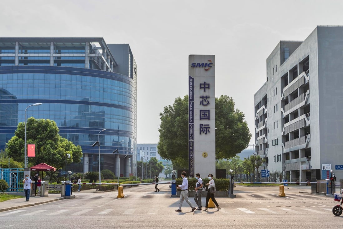 People walk in front of the gate of chip foundry Semiconductor Manufacturing International Corp’s headquarters in Shanghai on September 7. Photo: EPA-EFE