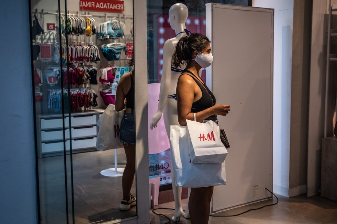 A shopper wearing a face mask carries an H&M branded shopping bag in Barcelona, Spain, in August. Photo: Bloomberg