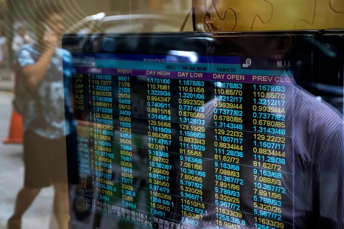 A stock brokerage in Hong Kong with a screen showing currency exchange rates on July 6, 2018. Photo: Agence France-Presse