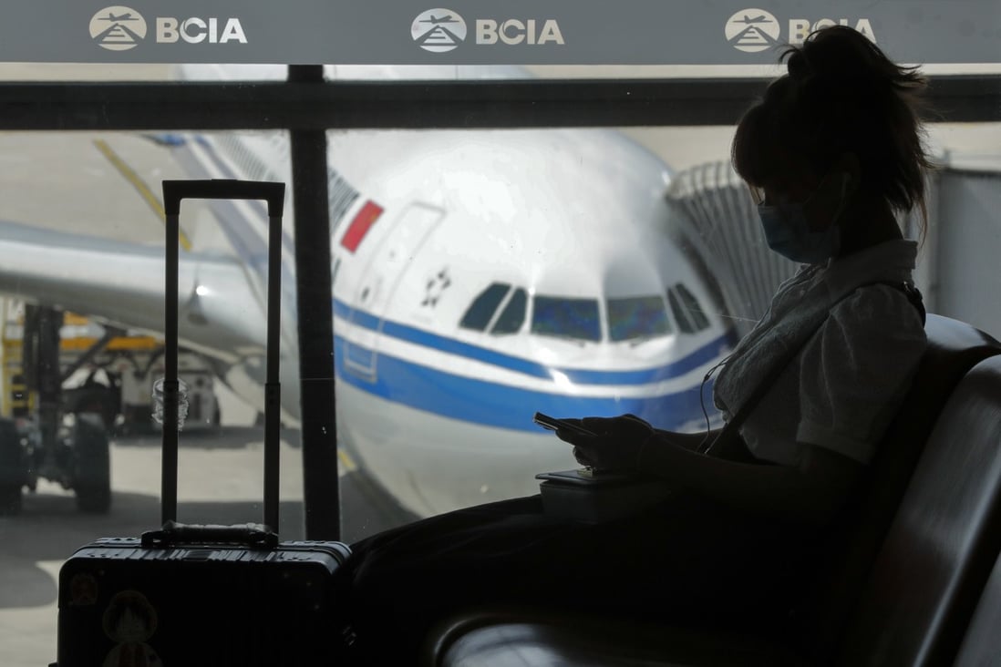 A woman wearing a face mask to help curb the spread of the coronavirus browses her smartphone at the Beijing Capital International Airport, on September 8, 2020. Photo: AP Photo
