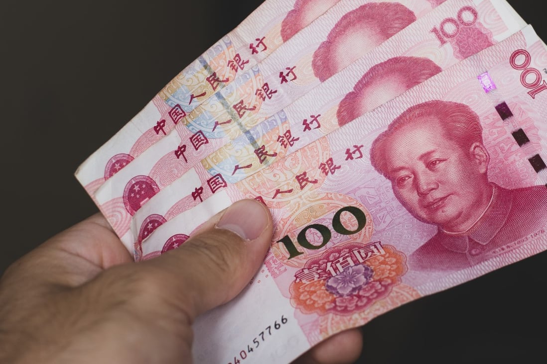 A person holds a stack of Chinese yuan bank notes. Photo: Shutterstock