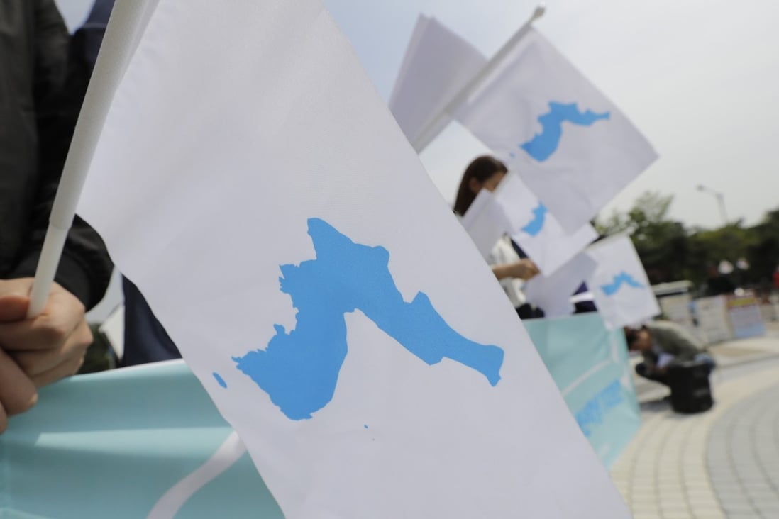 South Koreans hold unification flags showing the Korean peninsula at Moon and Kim’s 2018 summit. Photo: AP
