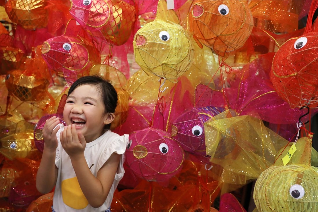 A young Hongkonger poses for a photo with fish-themed lanterns crafted for this year’s Mid-Autumn Festival. Photo: Sam Tsang