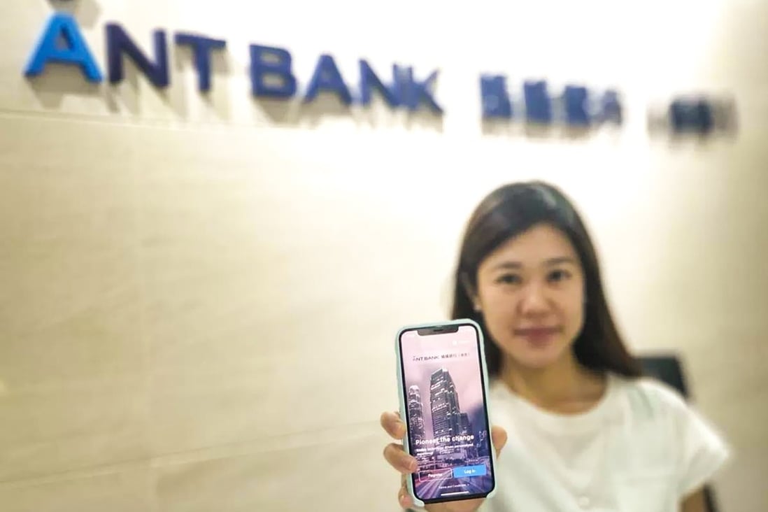 An Ant Bank staff holds up a smartphone showing the virtual bank app. Ant Bank is the virtual banking arm of Ant Group. Photo: Handout