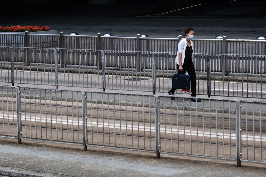 A pedestrian wearing a protective mask walks past metal railings next to tram tracks in Hong Kong on Friday. Photo: Bloomberg