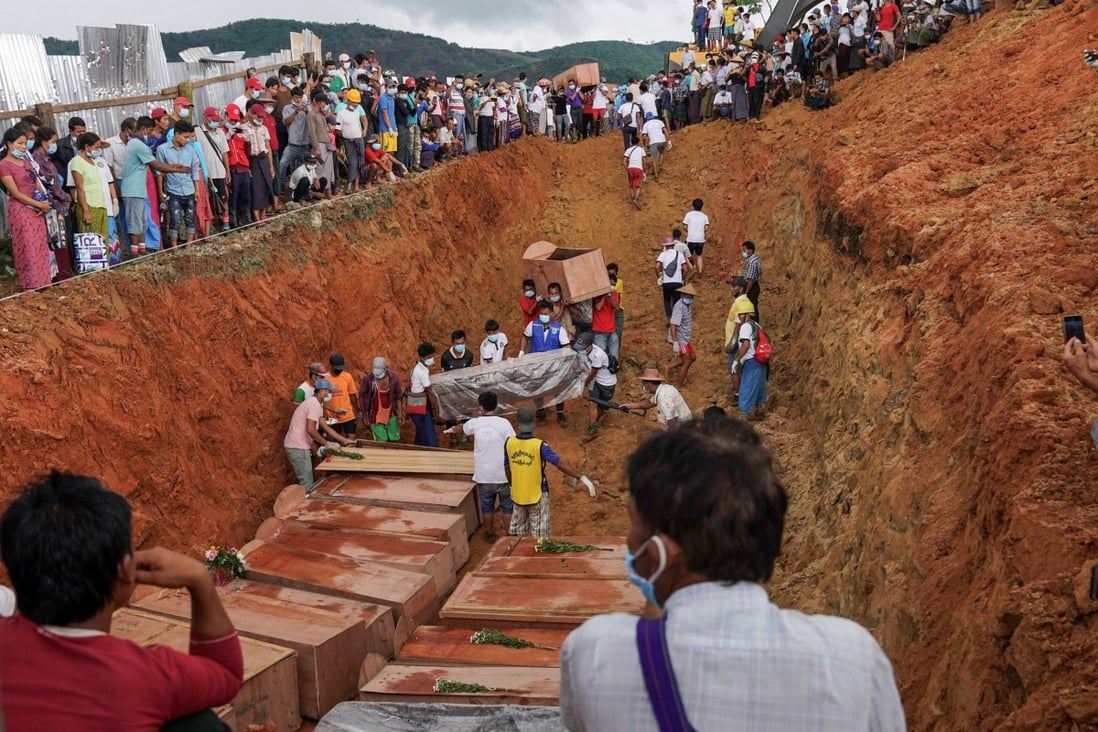 Volunteers bury bodies of miners in a mass grave as relatives look on during a funeral ceremony near Hpakant in Kachin state.Photo: AFP
