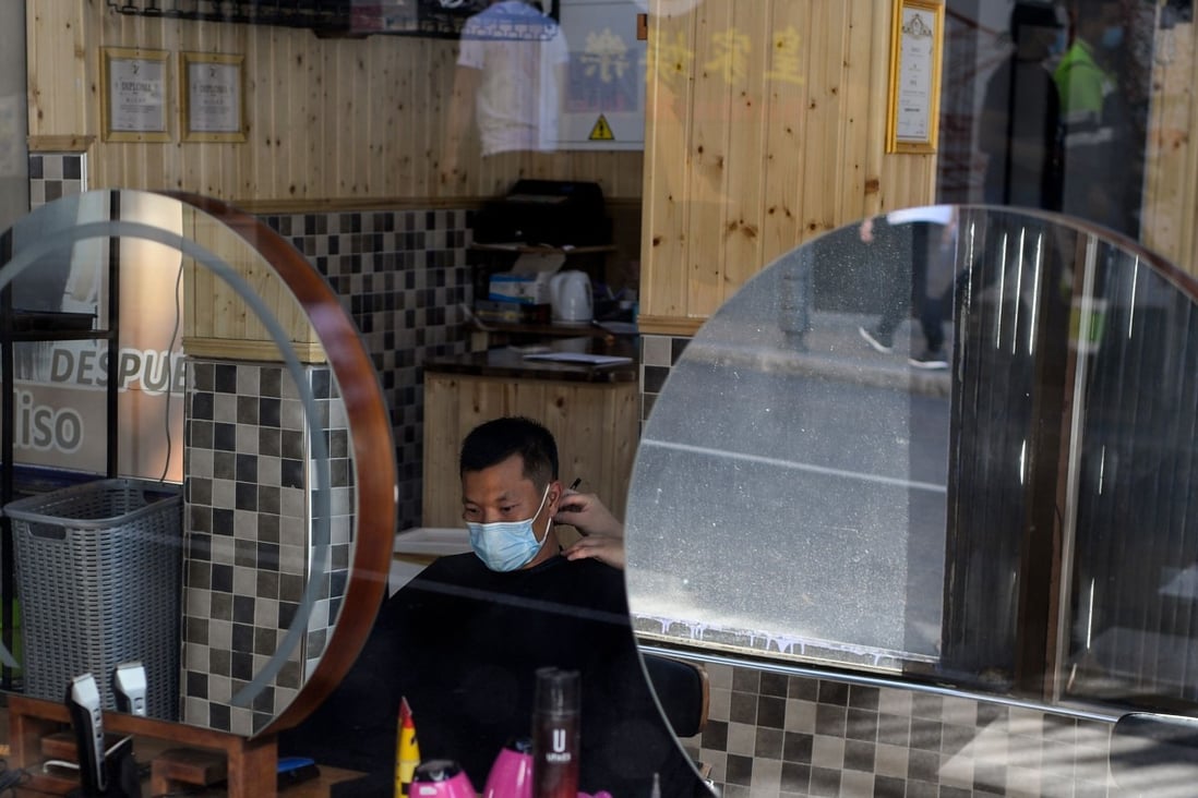 A man gets a haircut in Madrid, Spain. Residents will be barred from leaving except on essential trips under new rules to fight the coronavirus resurgence. Photo: AFP