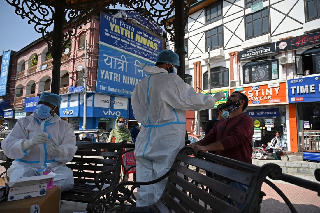 A medical worker collects a swab sample from a man in Srinagar, India. Photo: AFP