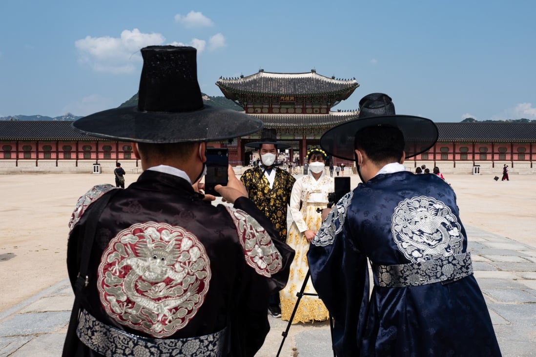 Filipino tourists wearing traditional Korean hanbok pose for photographs at the Gyeongbokgung Palace in Seoul on September 30. With Covid-19 going nowhere and widespread vaccines unlikely for another year, the imperative is to quickly establish protocols for safe travel. Photo: EPA-EFE