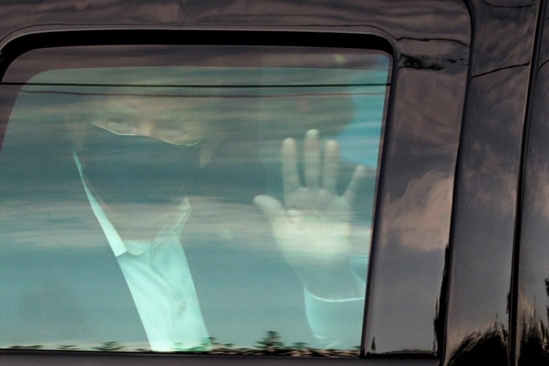 US President Donald Trump waves to supporters on Sunday as he briefly rides by in the presidential motorcade in front of Walter Reed National Military Medical Center, where he is being treated for coronavirus disease in Bethesda, Maryland. Photo: Reuters