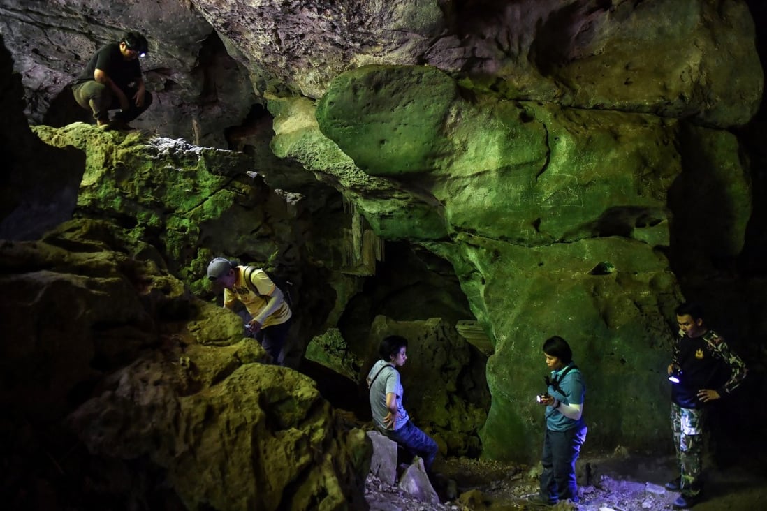Achaeologists look at newly-discovered cave paintings in Khao Sam Roi Yot national park in Thailand. Photo: Lillian Suwanrumpha/AFP