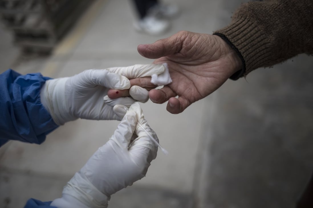 A health care worker takes a blood sample during a house-to-house rapid antibody test drive in Villa el Salvador, on the outskirts of Lima, Peru in June. Photo: AP