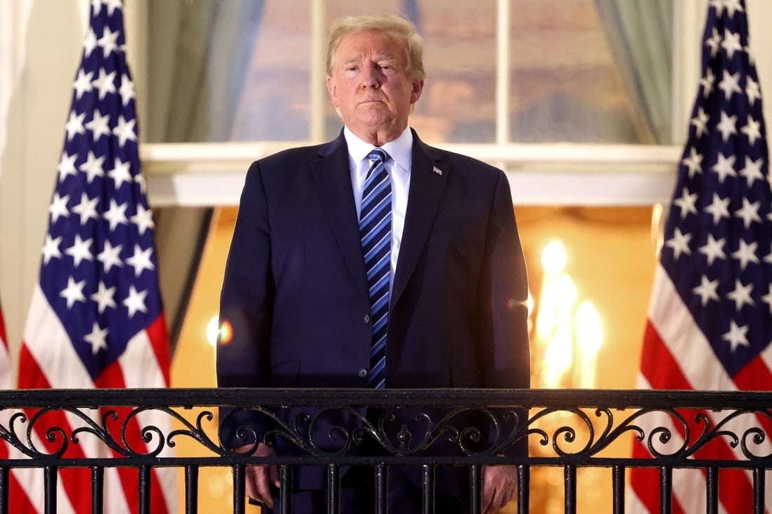 US President Donald Trump is seen on a balcony of the White House on Monday after returning from hospital. Photo: Getty Images