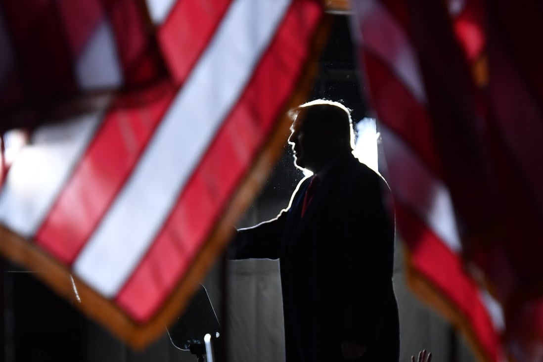 US President Donald Trump is seen behind US flags as he speaks to supporters at a “Great American Comeback” event in Mosinee, Wisconsin, on September 17. Photo: AFP