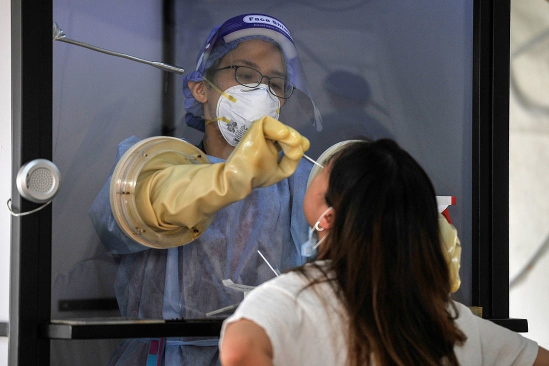 A health worker in Petaling Jaya tests a woman for coronavirus amid the recent surge. Photo: DPA
