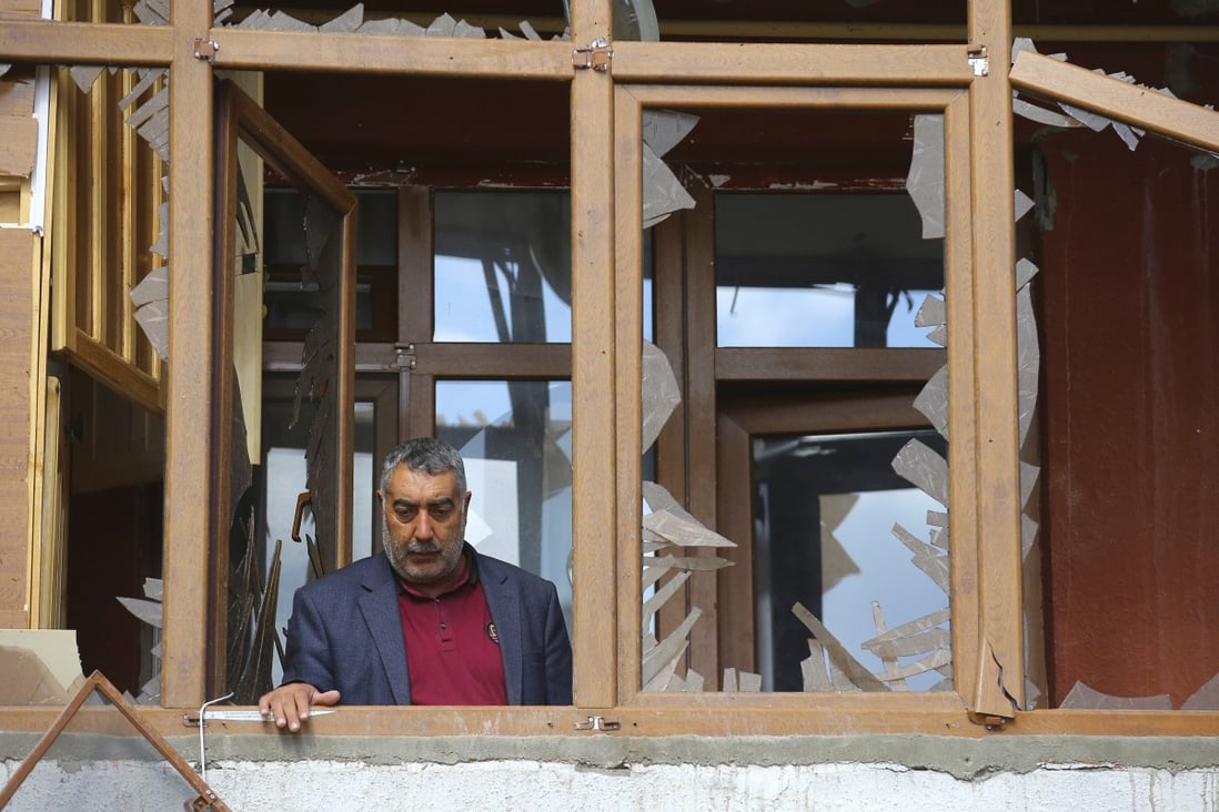 A man stands in a balcony as he examines the damage to his flat after shelling by Armenian artillery during fighting over the separatist region of Nagorno-Karabakh, in Terter, Azerbaijan on Saturday. Photo: AP Photo