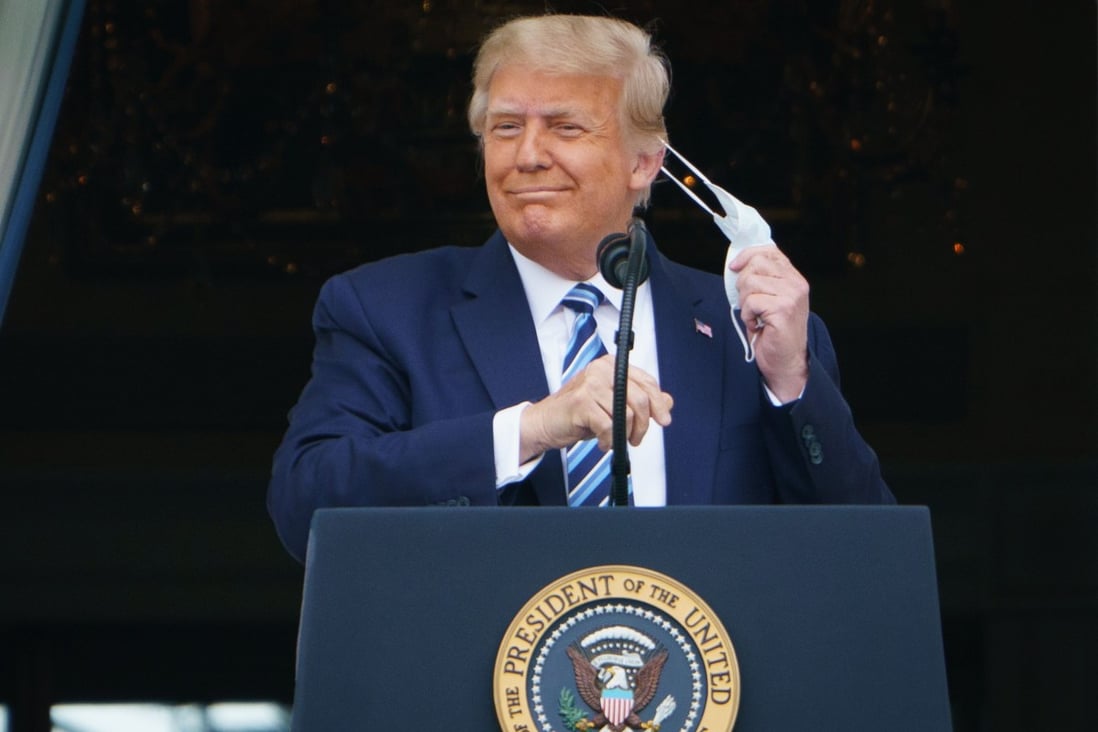 US President Donald Trump takes his mask off before speaking from the South Portico of the White House in Washington, DC during a rally on Saturday. Photo: AFP