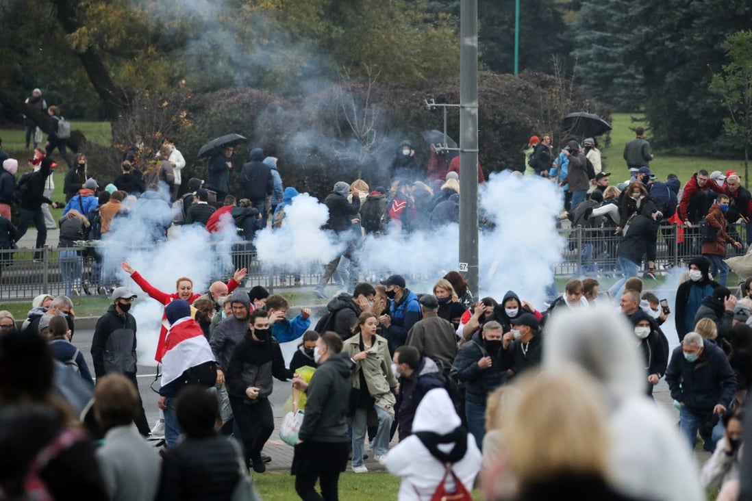 Demonstrators react as a stun grenade explodes during an opposition rally to reject the presidential election results in Minsk, Belarus on Sunday. Photo: BelaPAN via Reuters