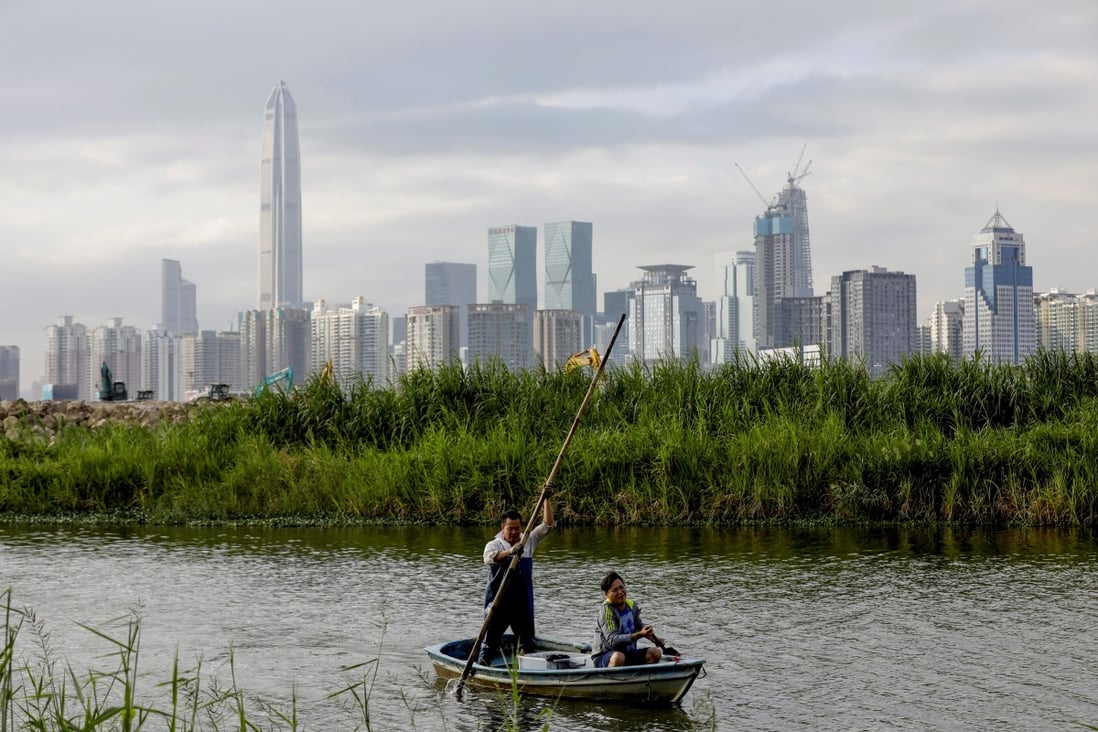A fisherman returns to his home in Lok Ma Chau village, in Hong Kong, with the Shenzhen skyline visible in the distance. Photo: Reuters