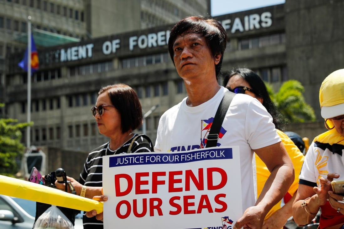 An activist holds a banner during a protest in Manila against the sinking of a Philippine fishing boat by a Chinese vessel in June 2019. Philippine military officials have raised the possibility of forming a seaborne militia. Photo: EPA
