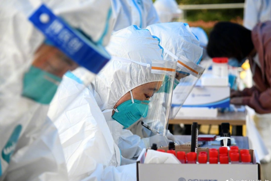 Medical staff collect Covid-19 samples near a residential area in Qingdao on Friday. Photo: Xinhua