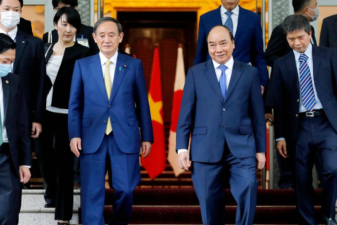 Japan's Prime Minister Yoshihide Suga (centre left) and Vietnam's Prime Minister Nguyen Xuan Phuc (centre right) at the Government Office in Hanoi on October 19. Photo: AFP