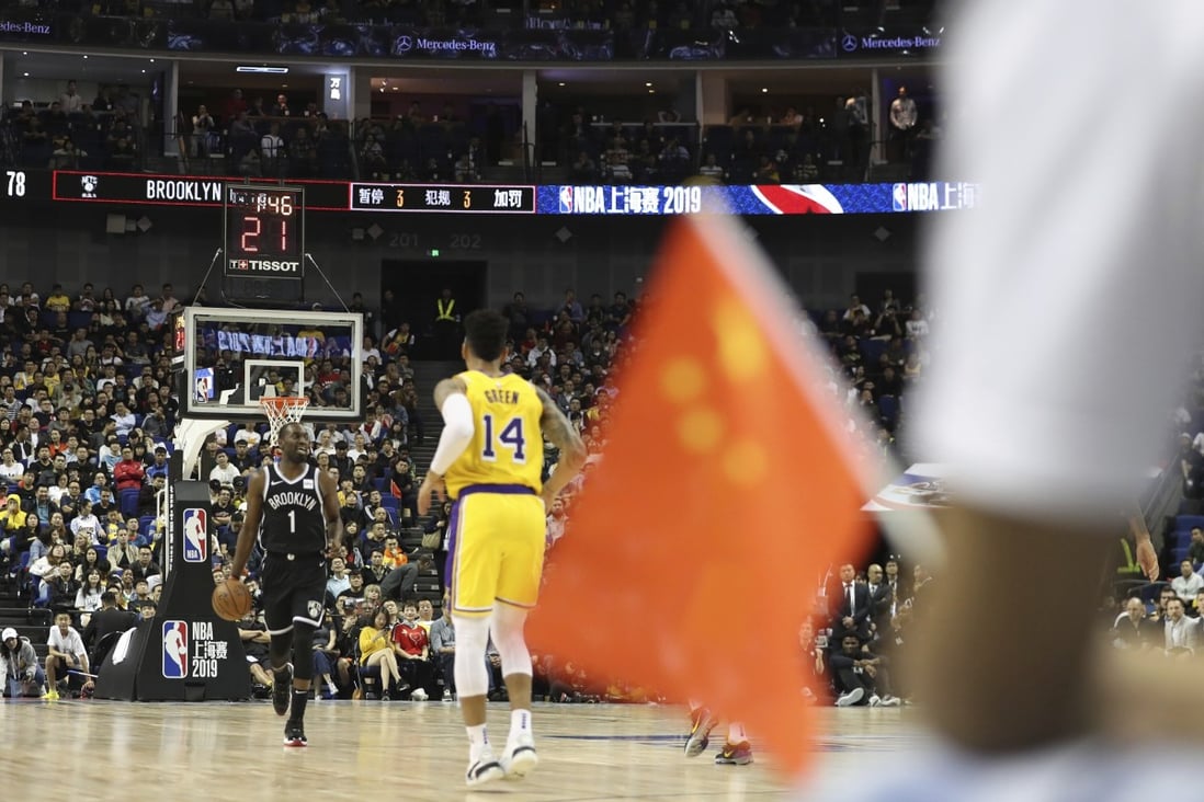 The Brooklyn Nets and Los Angeles Lakers play the 2019 NBA China Games as a fan holds a Chinese national flag in Shanghai’s Mercedes-Benz Arena. Photo: AP