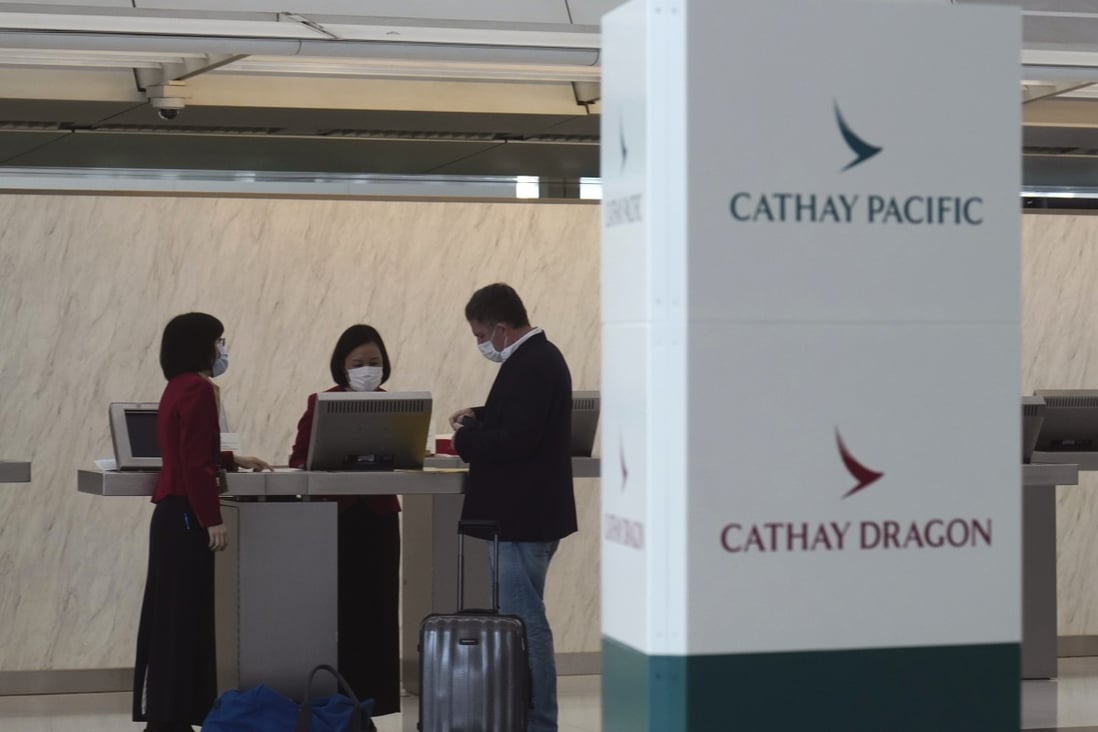 A passenger checks in at the Cathay Pacific counter at the Hong Kong International Airport, on Wednesday. The airline said it would cut 8,500 jobs and shut down its regional airline unit as part of a corporate restructuring. Photo: AP Photo